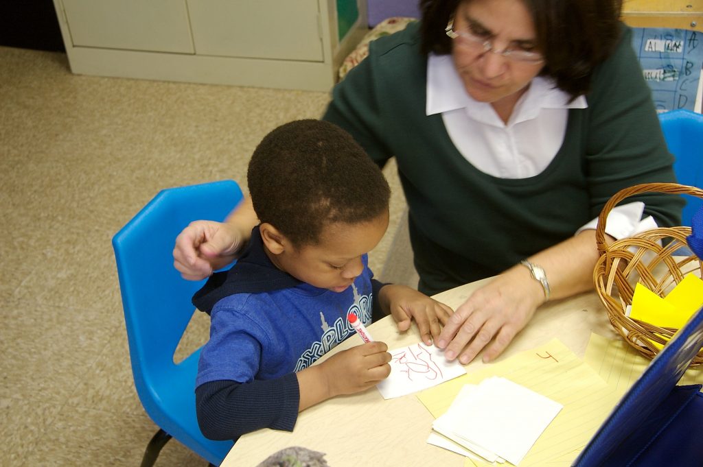Teacher at table with preschooler