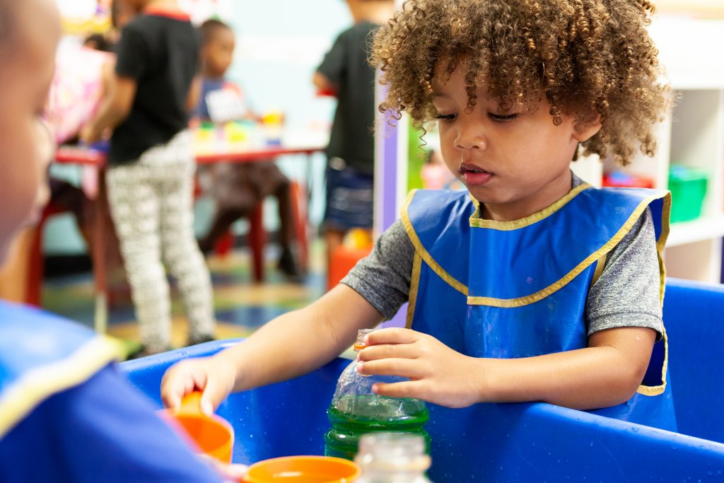 young boy playing at a water table